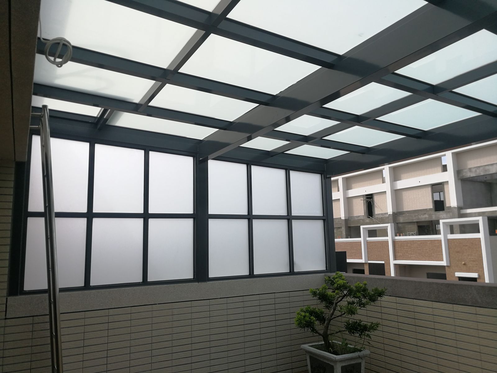 屋頂玻璃採用5+5膠合白膜玻璃,左側固定窗豆腐格5mm噴砂強化玻璃