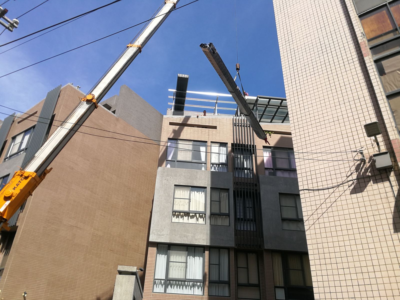 使用吊車將玻璃屋材料及鋼管吊至頂樓陽台