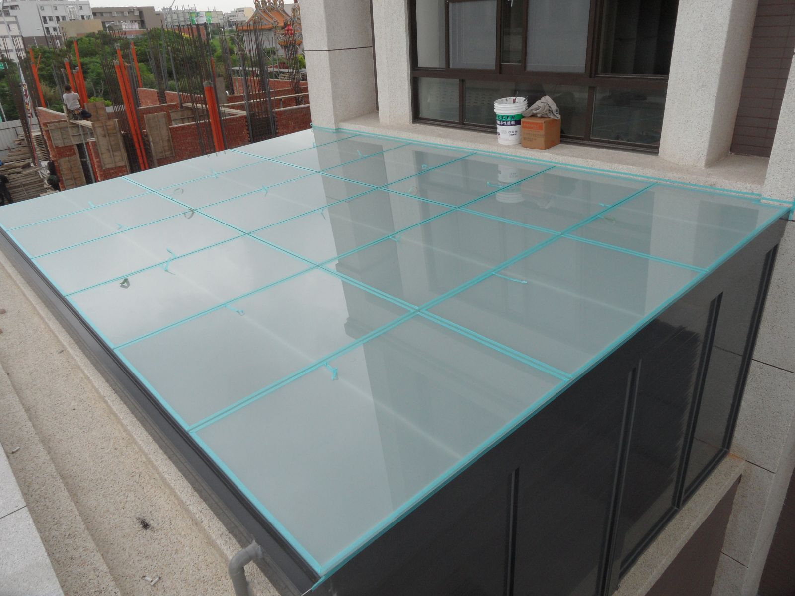 屋頂玻璃採用5+5膠合白膜玻璃,間隙為1公分伸縮縫將玻璃四周以紙膠帶黏貼後施打矽利康
